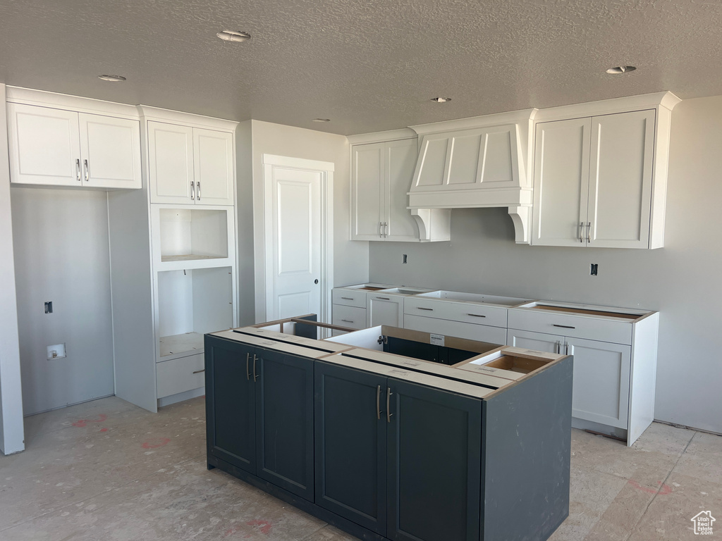 Kitchen with a kitchen island and white cabinetry