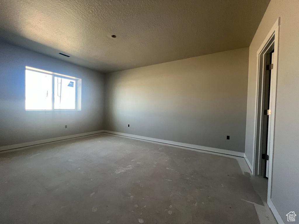 Empty room with concrete floors and a textured ceiling