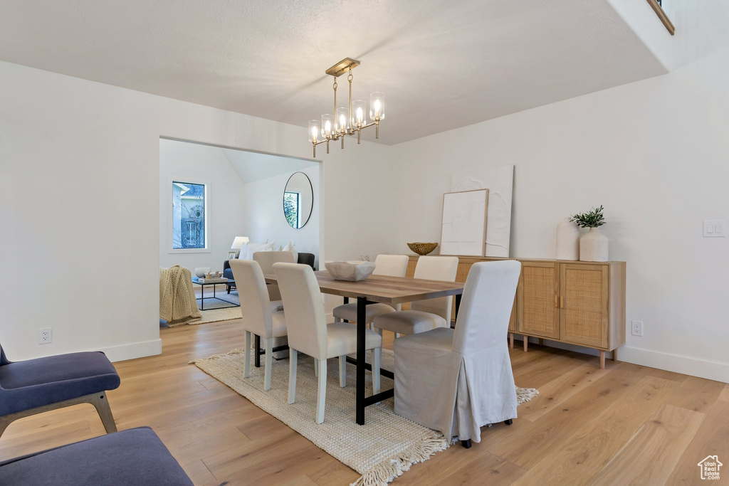 Dining area with light hardwood / wood-style floors and a chandelier