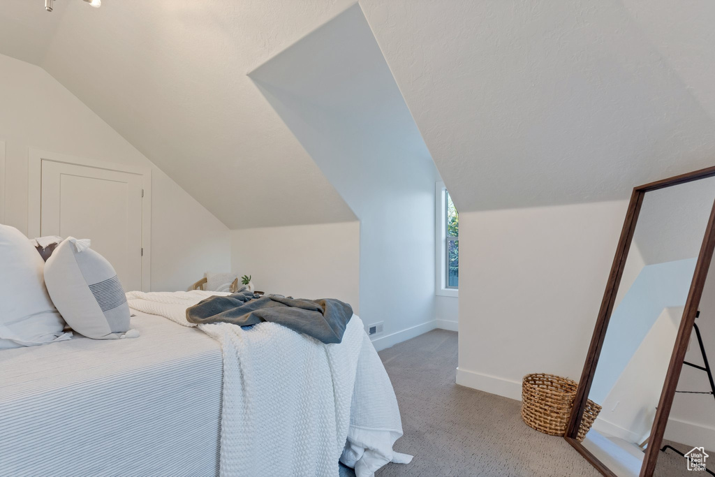 Bedroom featuring carpet flooring and lofted ceiling