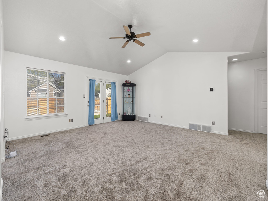 Empty room with french doors, light carpet, ceiling fan, and lofted ceiling