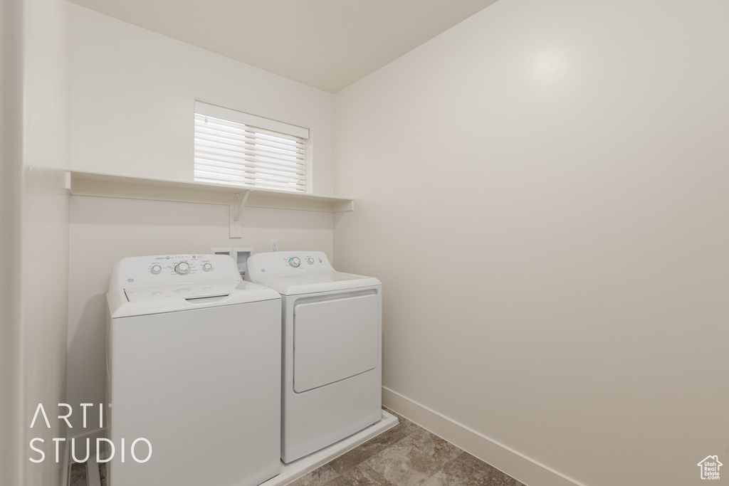 Laundry room with tile flooring and independent washer and dryer