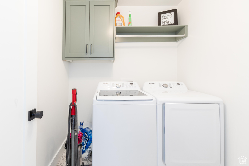 Laundry room featuring washer and dryer and cabinets