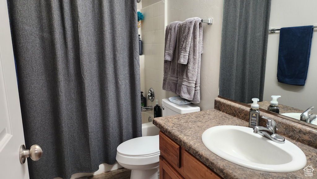 Full bathroom with shower / tub combo with curtain, vanity, and toilet