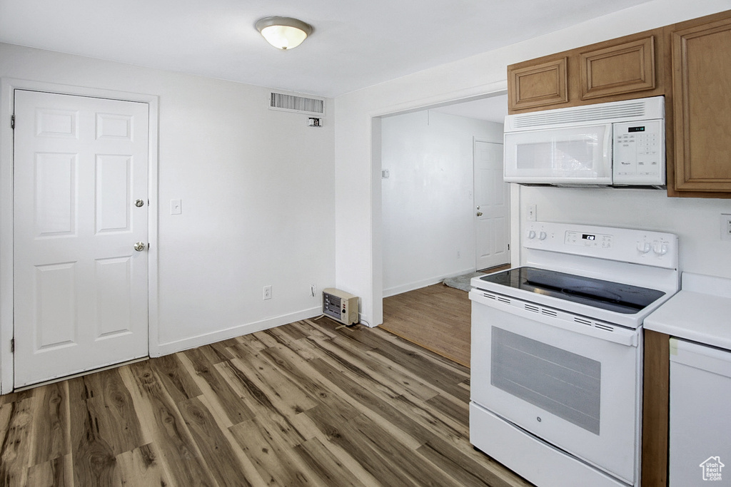 Kitchen with white appliances and hardwood / wood-style floors