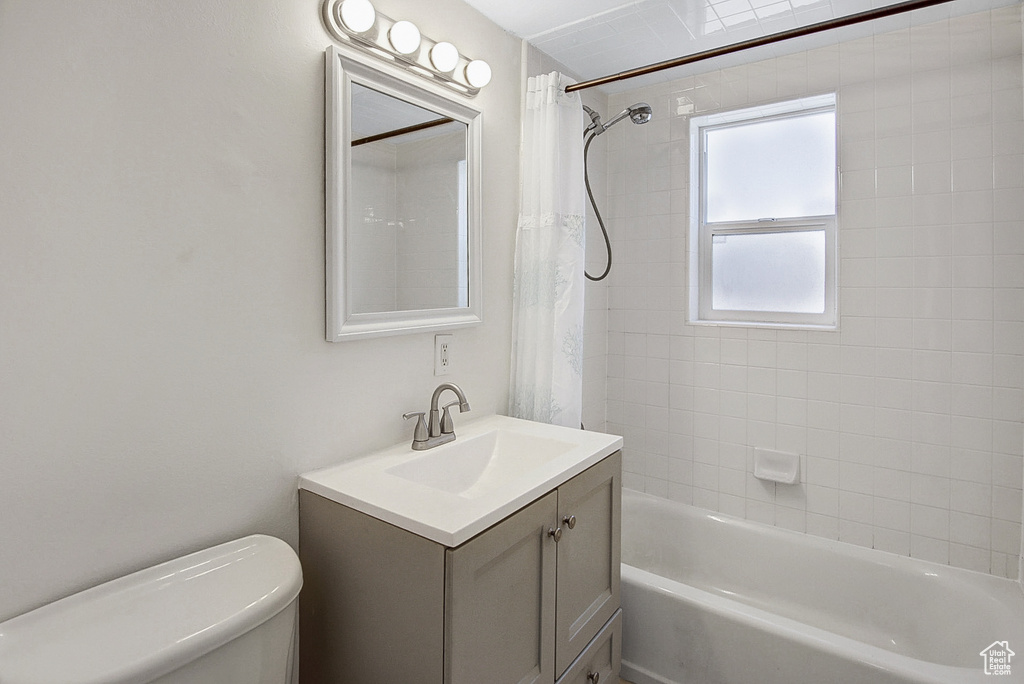 Full bathroom featuring vanity, shower / bath combo, and toilet