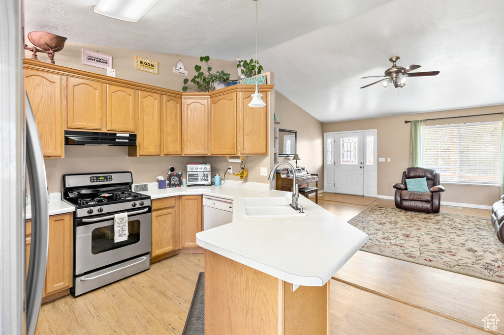 Kitchen with gas stove, kitchen peninsula, sink, vaulted ceiling, and ceiling fan