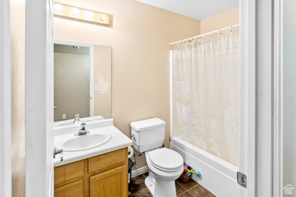 Full bathroom featuring shower / bathtub combination with curtain, toilet, tile flooring, and vanity