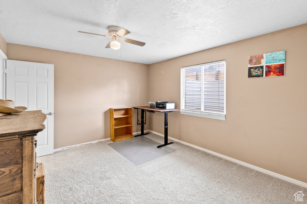 Office area featuring a textured ceiling, ceiling fan, and carpet flooring