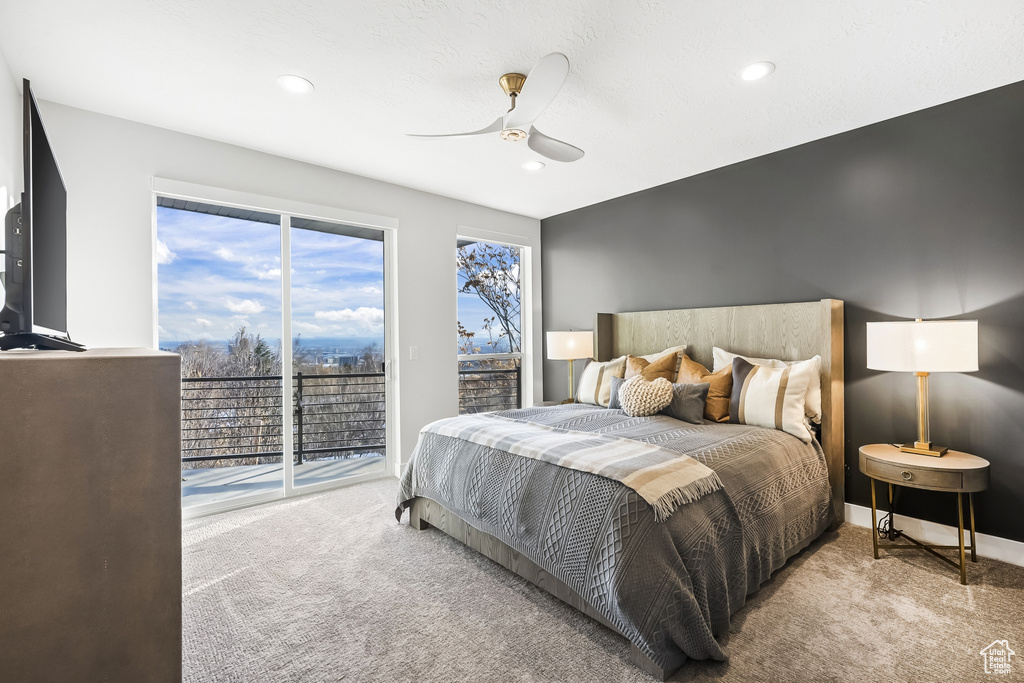 Bedroom with light colored carpet, ceiling fan, and access to outside