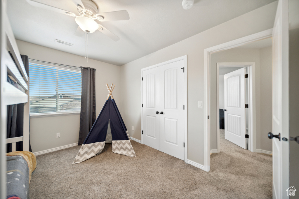 Recreation room with light colored carpet and ceiling fan