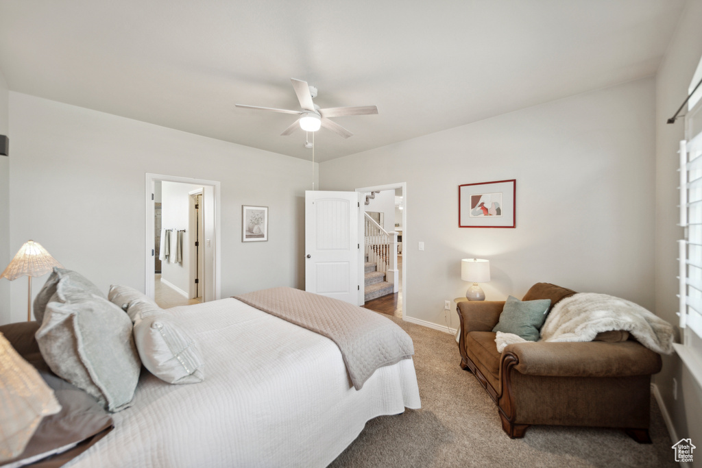 Bedroom featuring ceiling fan, carpet, and ensuite bathroom