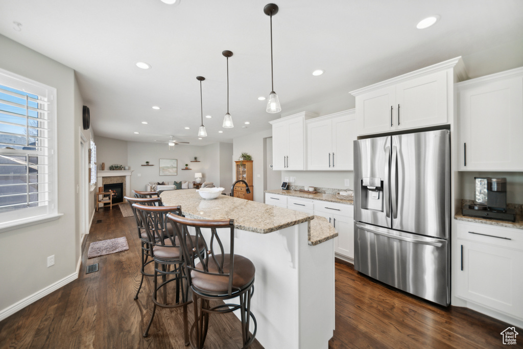 Kitchen featuring white cabinets, stainless steel refrigerator with ice dispenser, and dark wood-type flooring