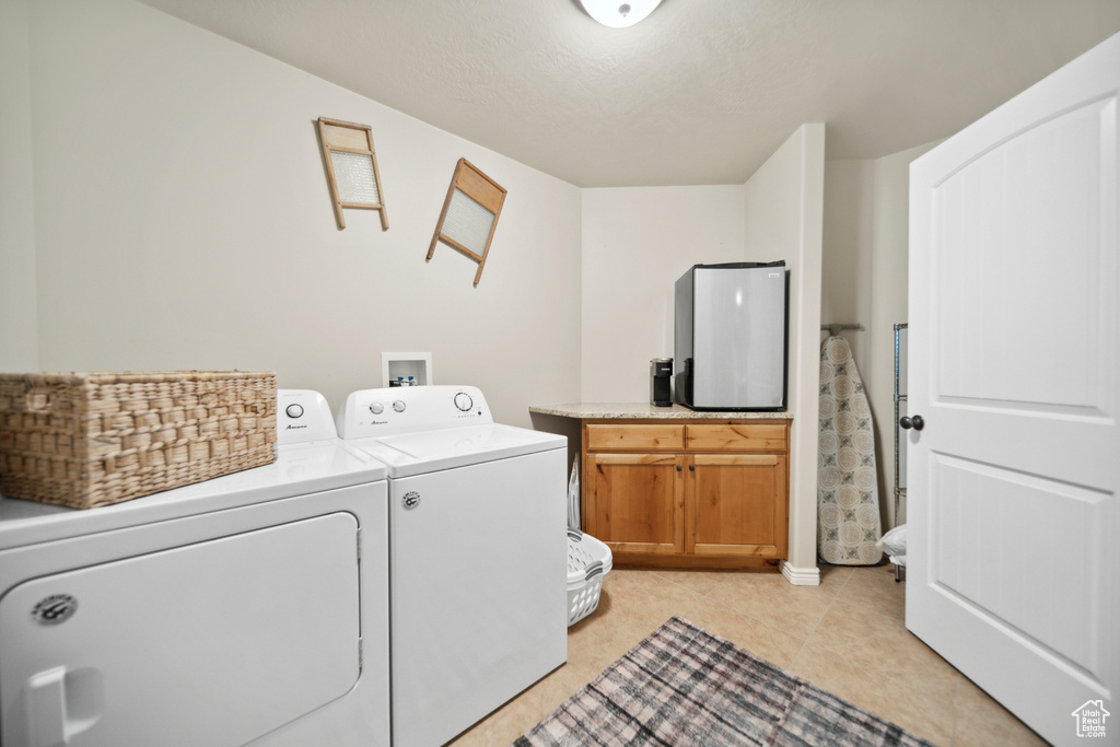 Washroom featuring cabinets, separate washer and dryer, washer hookup, and light tile floors