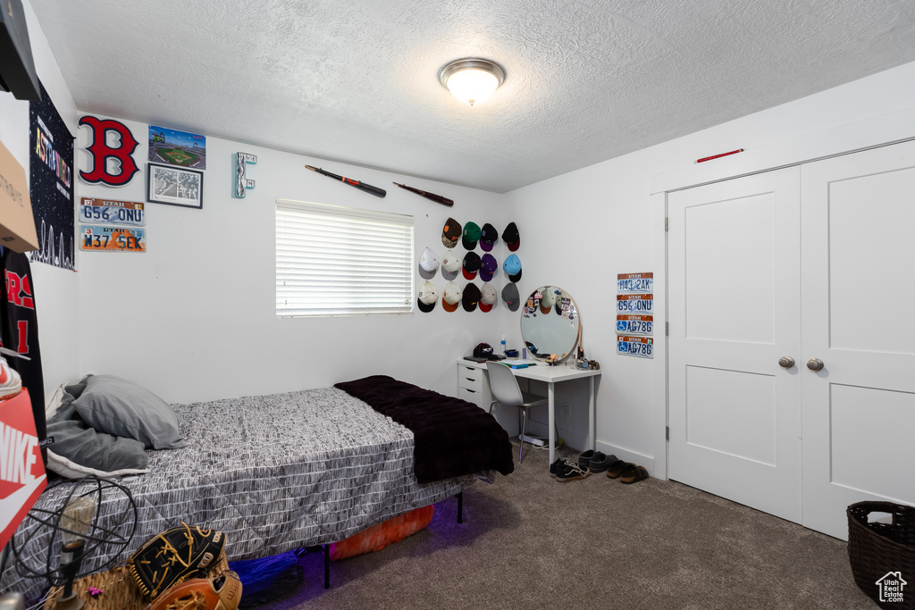 Carpeted bedroom with a closet and a textured ceiling