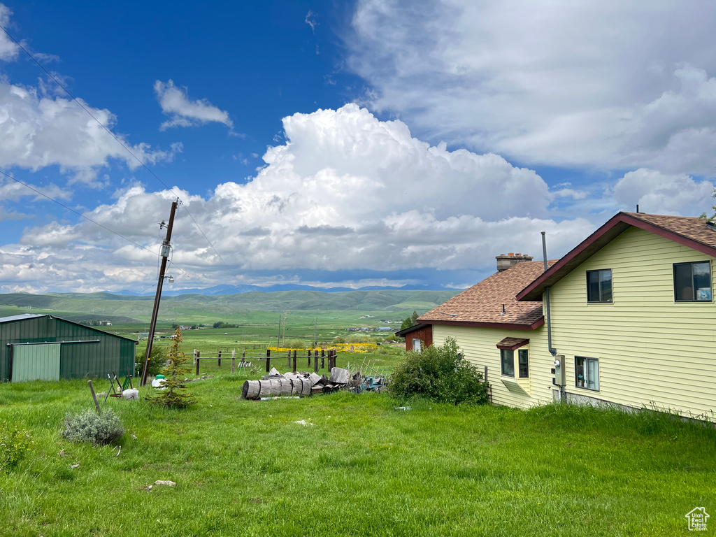 View of yard featuring a mountain view, a rural view, and an outdoor structure