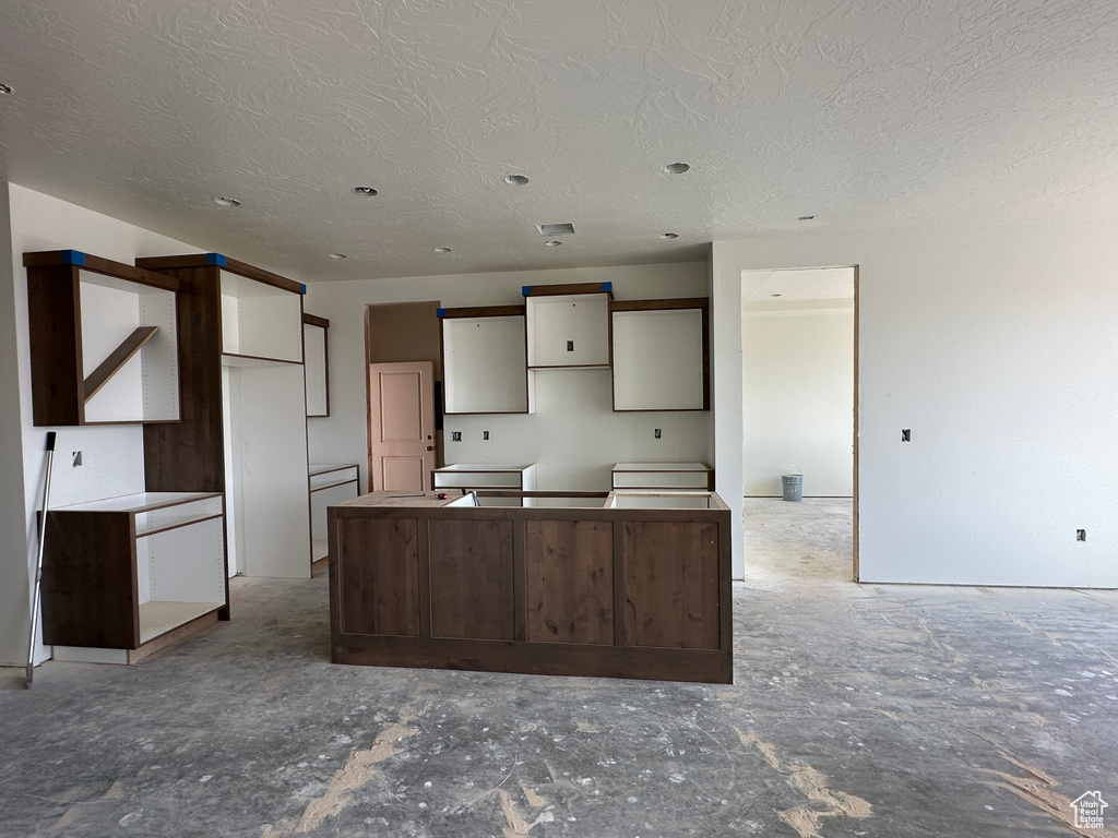 Kitchen with a textured ceiling and a kitchen island