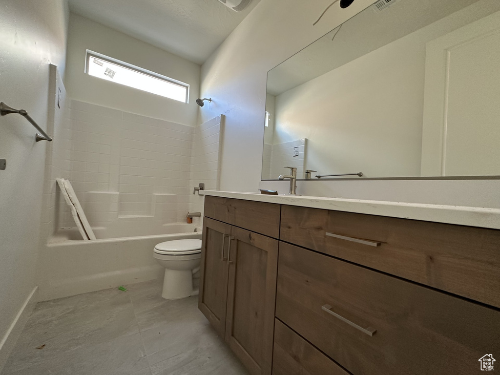 Full bathroom featuring vanity, washtub / shower combination, and toilet