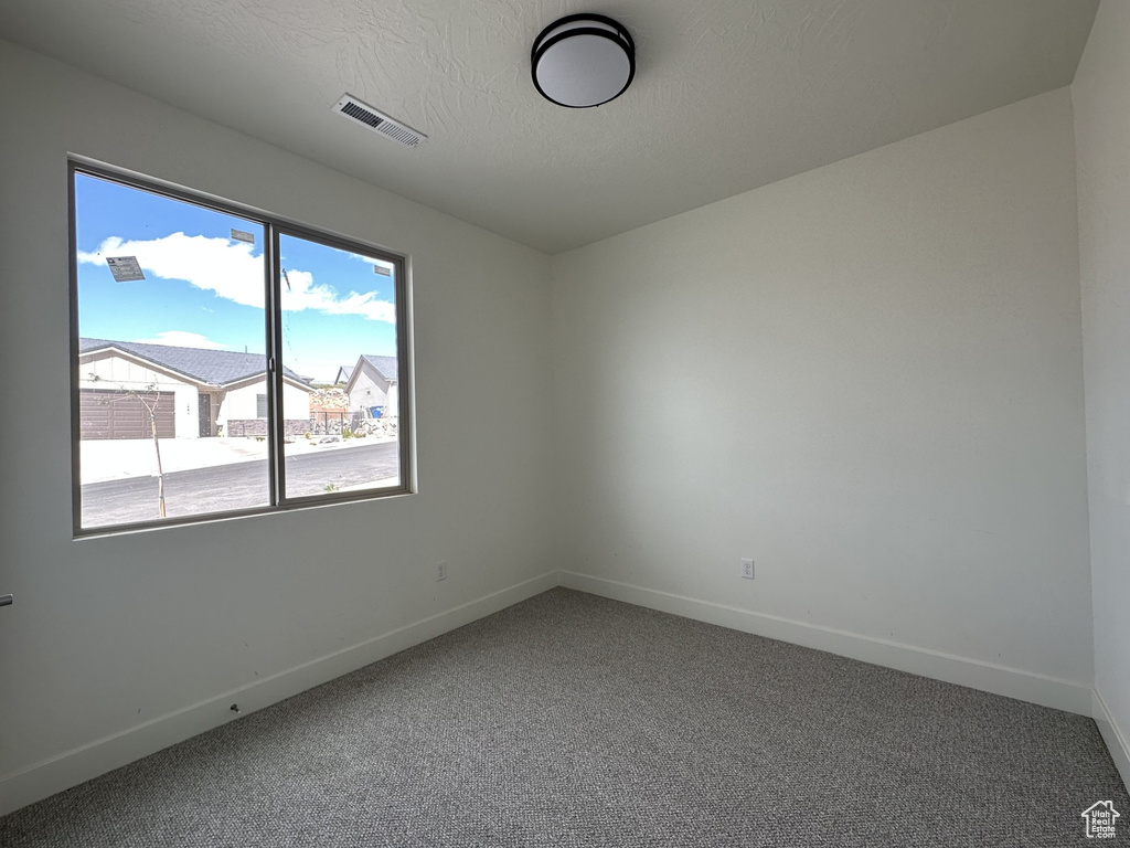 Carpeted spare room featuring a textured ceiling