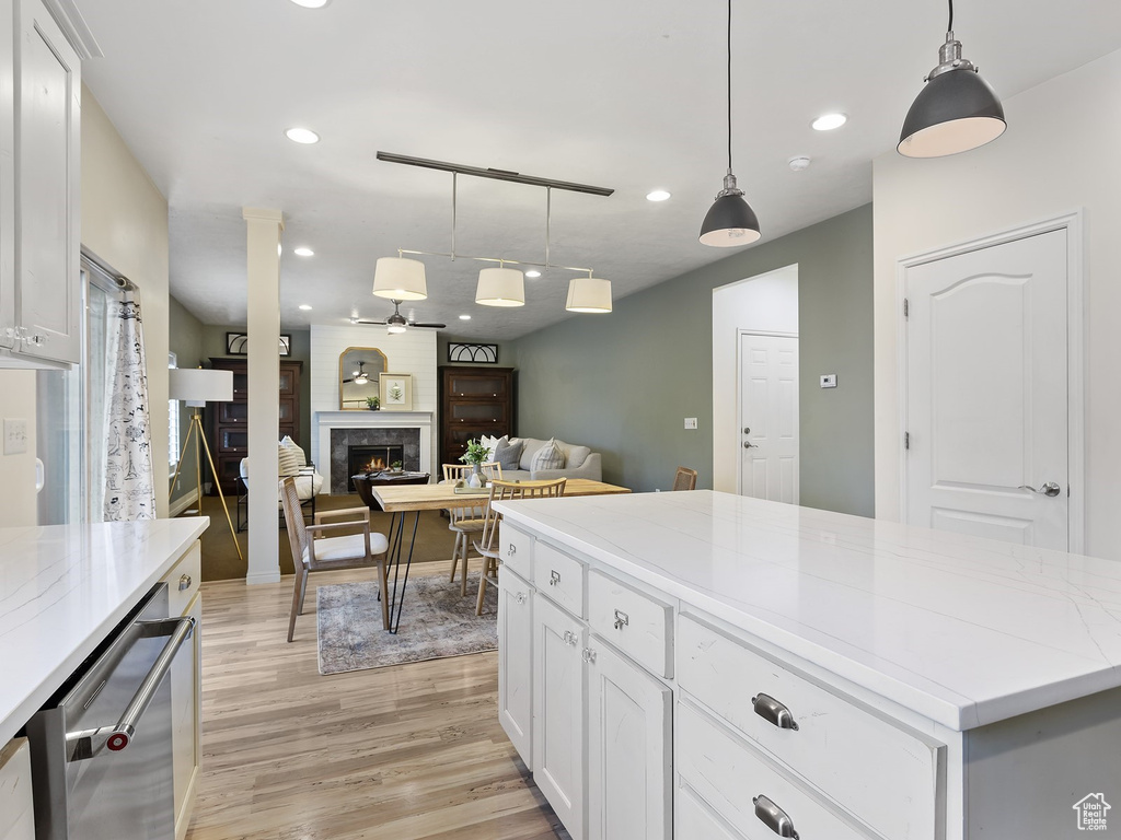 Kitchen with light hardwood / wood-style flooring, decorative light fixtures, white cabinets, and track lighting