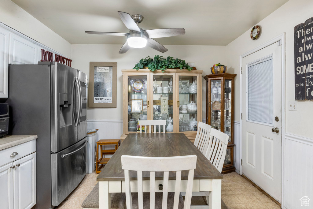 Kitchen with white cabinets, ceiling fan, light tile floors, and stainless steel fridge with ice dispenser