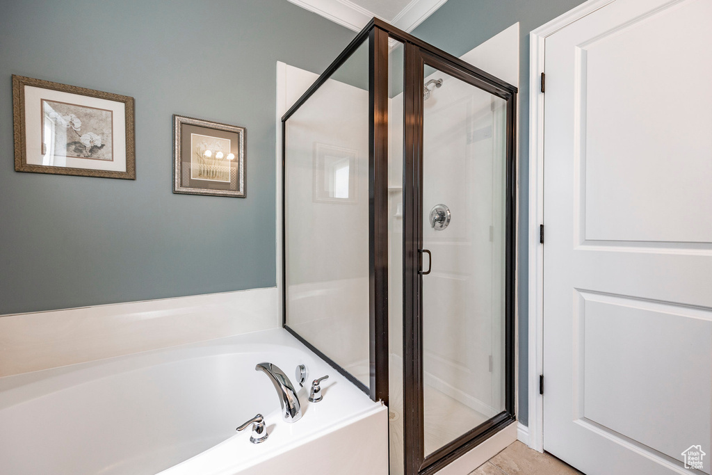 Bathroom featuring crown molding and separate shower and tub