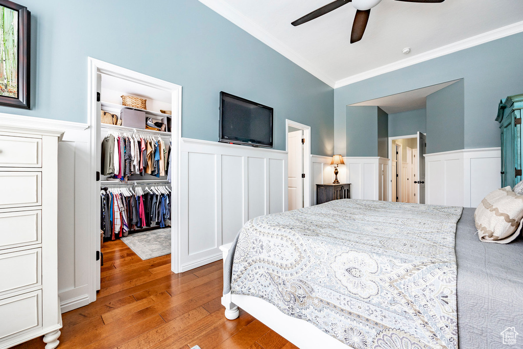 Bedroom with ceiling fan, hardwood / wood-style flooring, and ornamental molding