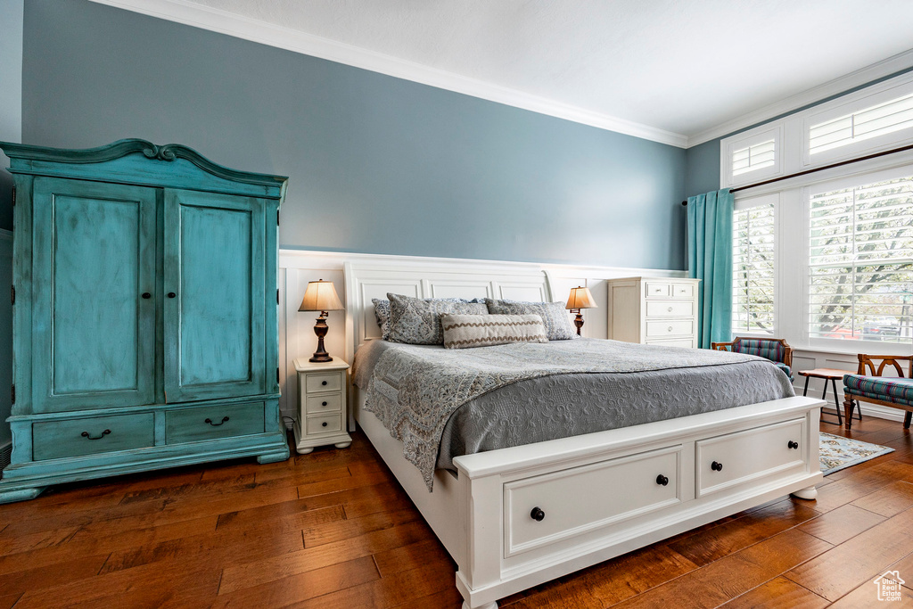 Bedroom featuring dark hardwood / wood-style flooring and crown molding