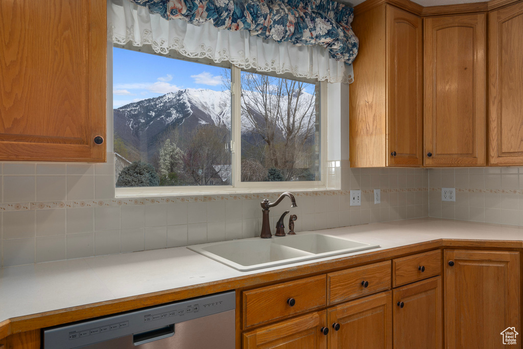 Kitchen with sink, a mountain view, tasteful backsplash, and stainless steel dishwasher