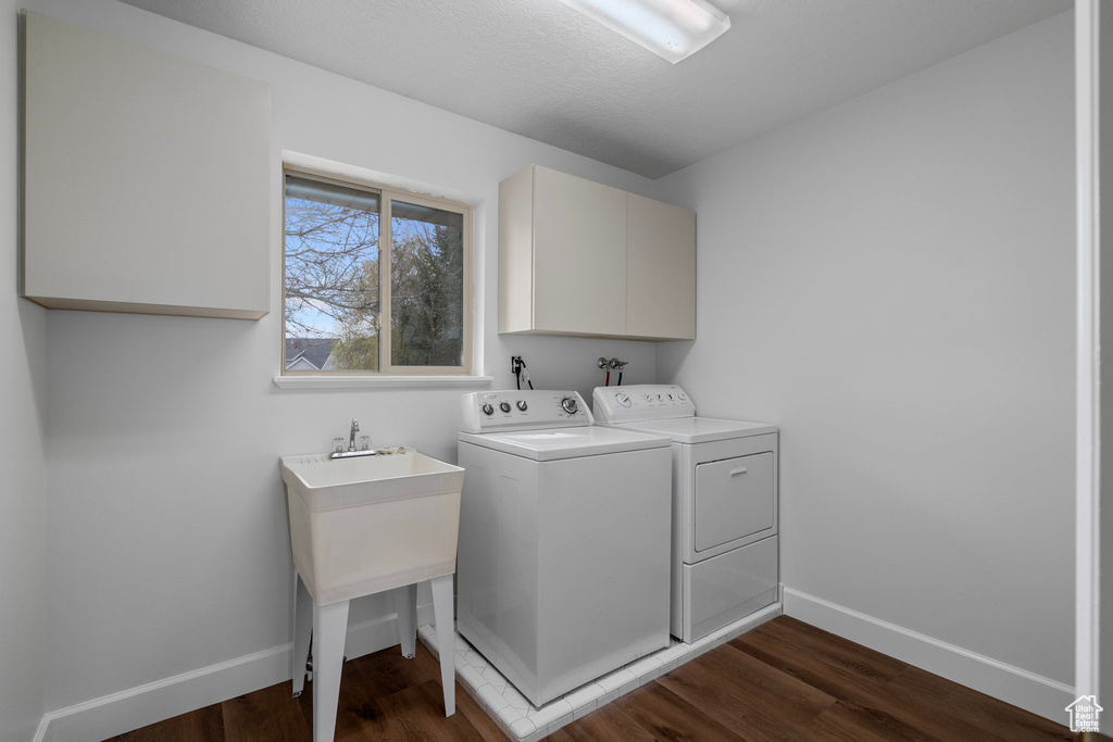 Laundry room featuring cabinets, hardwood / wood-style floors, washer hookup, and washing machine and clothes dryer