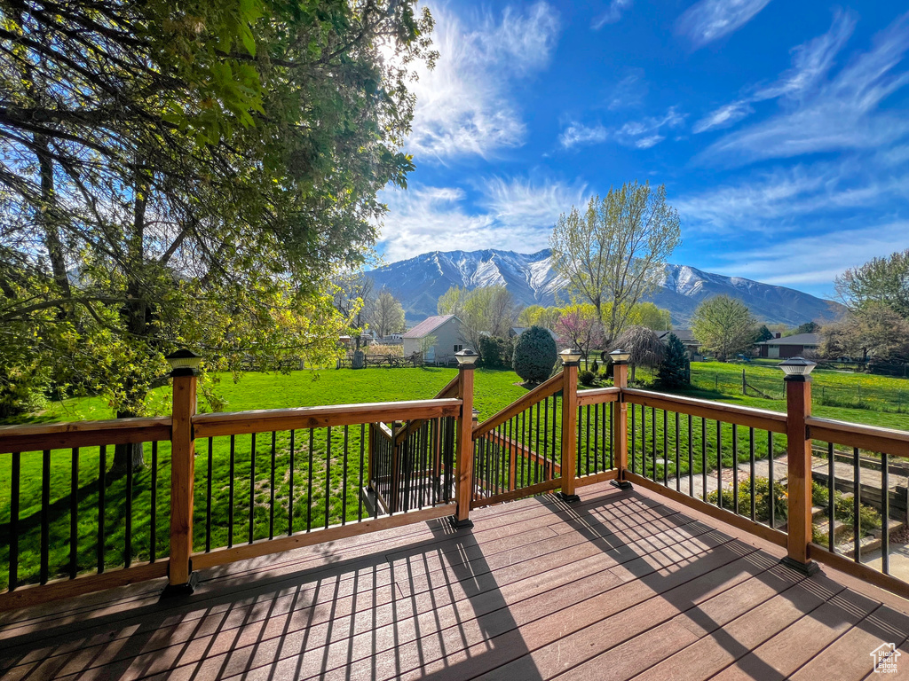 Deck with a mountain view and a yard
