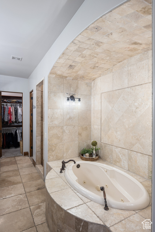 Bathroom with tile flooring and tile walls