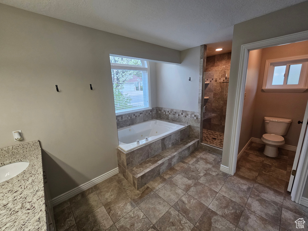 Full bathroom with independent shower and bath, toilet, tile flooring, a textured ceiling, and vanity