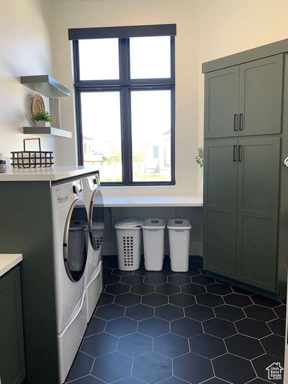 Laundry area with tile floors, washing machine and dryer, and cabinets
