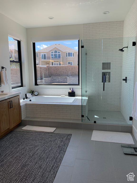 Bathroom with independent shower and bath, vanity, and tile flooring