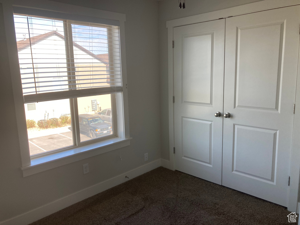 Unfurnished bedroom featuring carpet, a closet, and multiple windows