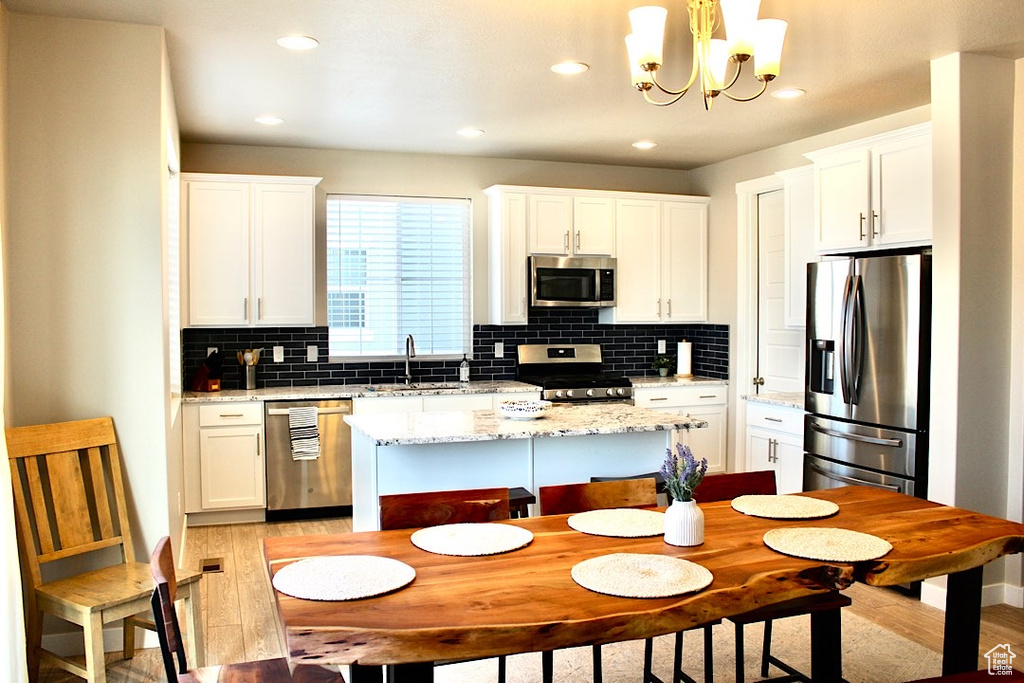 Kitchen featuring tasteful backsplash, appliances with stainless steel finishes, sink, and light wood-type flooring