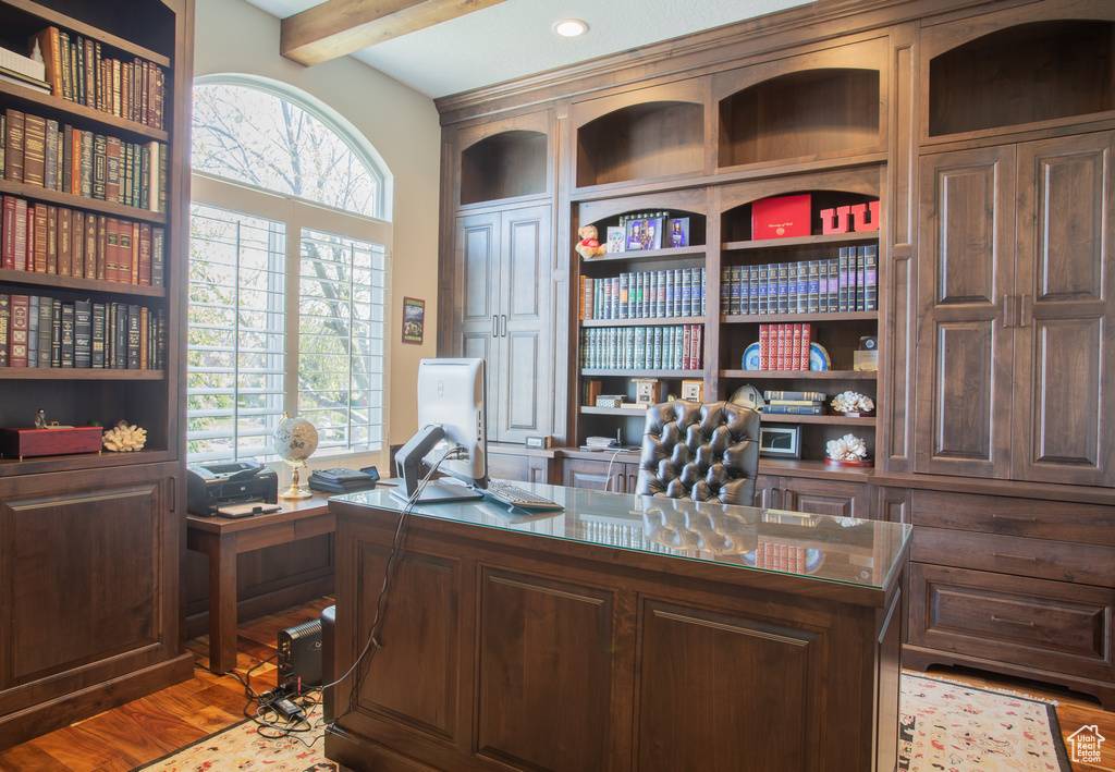Home office with beam ceiling and hardwood / wood-style flooring