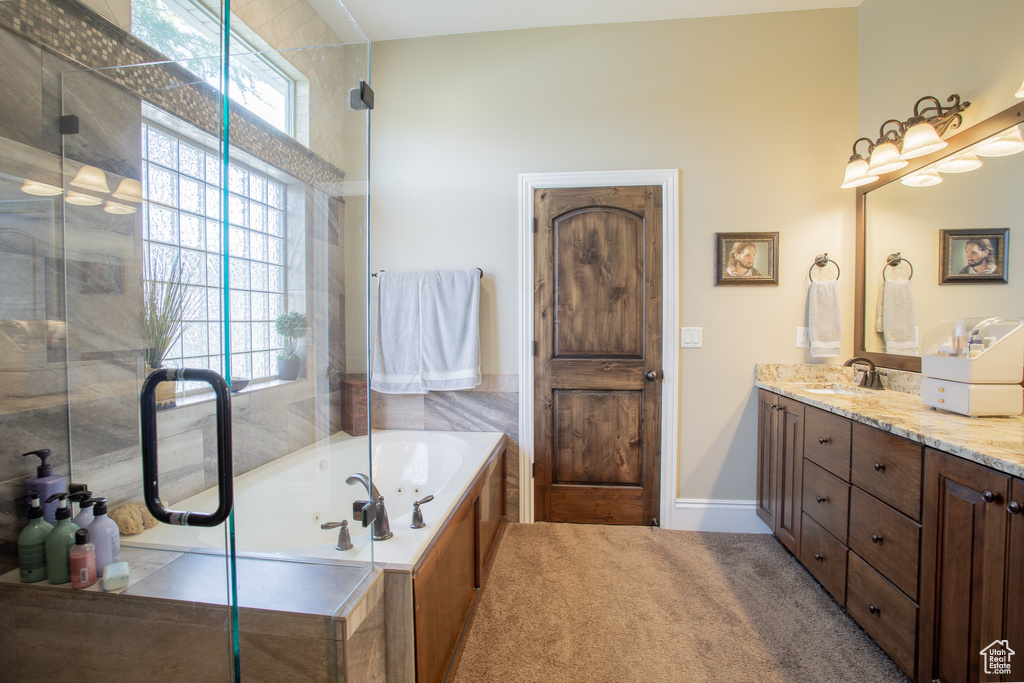 Bathroom with double vanity, a wealth of natural light, and plus walk in shower