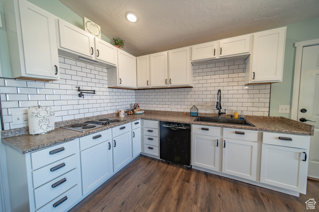 Kitchen featuring backsplash, sink, dark hardwood / wood-style flooring, and black dishwasher