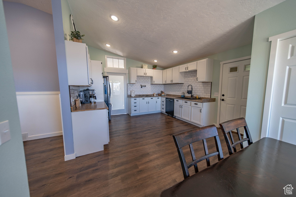 Kitchen featuring white cabinets, sink, tasteful backsplash, stainless steel appliances, and dark hardwood / wood-style floors