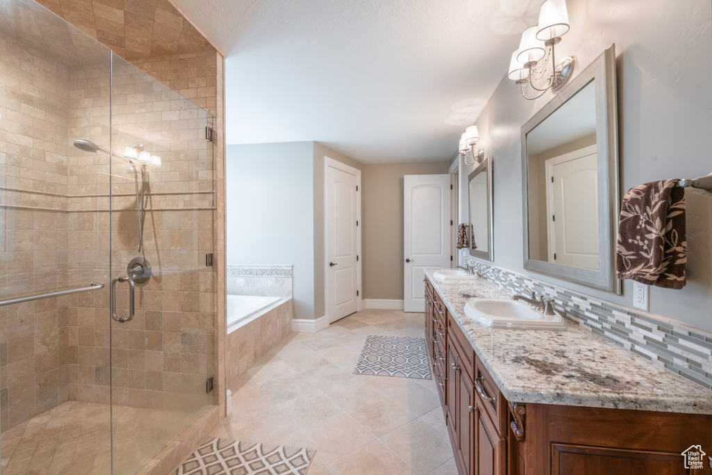 Bathroom featuring tasteful backsplash, tile floors, shower with separate bathtub, and dual vanity