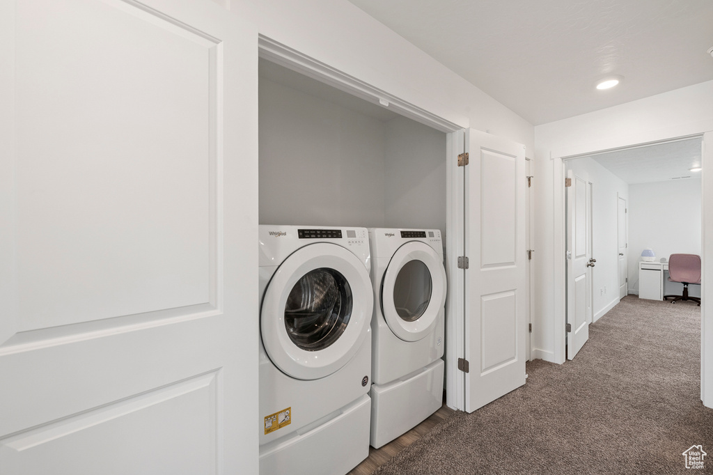 Laundry area featuring dark carpet and washer and dryer