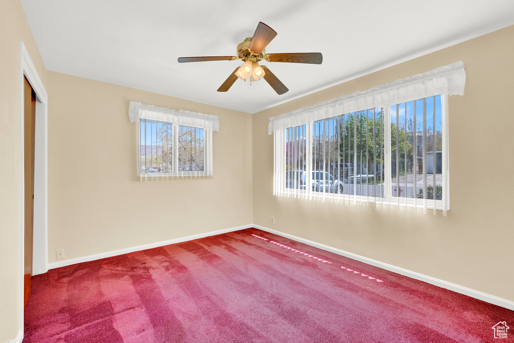 Empty room with carpet flooring and ceiling fan