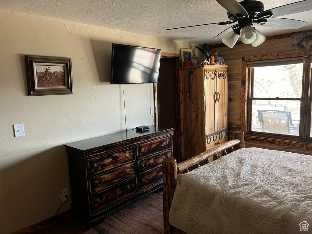 Bedroom featuring ceiling fan, dark hardwood / wood-style floors, and a textured ceiling