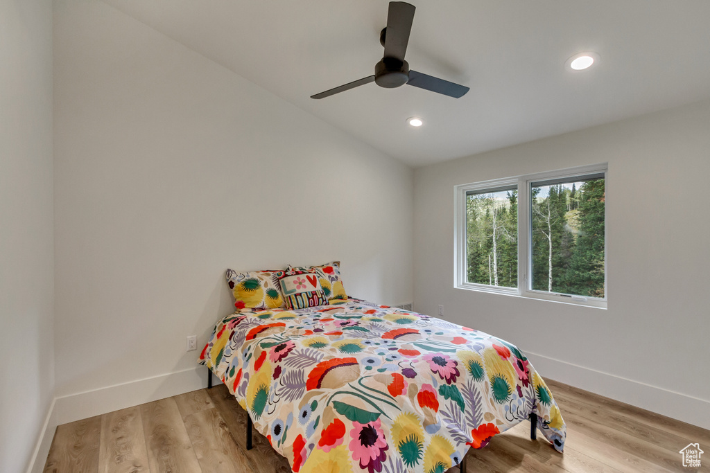 Bedroom with vaulted ceiling, ceiling fan, and hardwood / wood-style floors