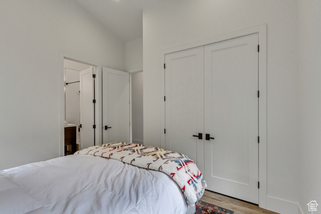 Bedroom with light hardwood / wood-style floors, a closet, and ensuite bathroom