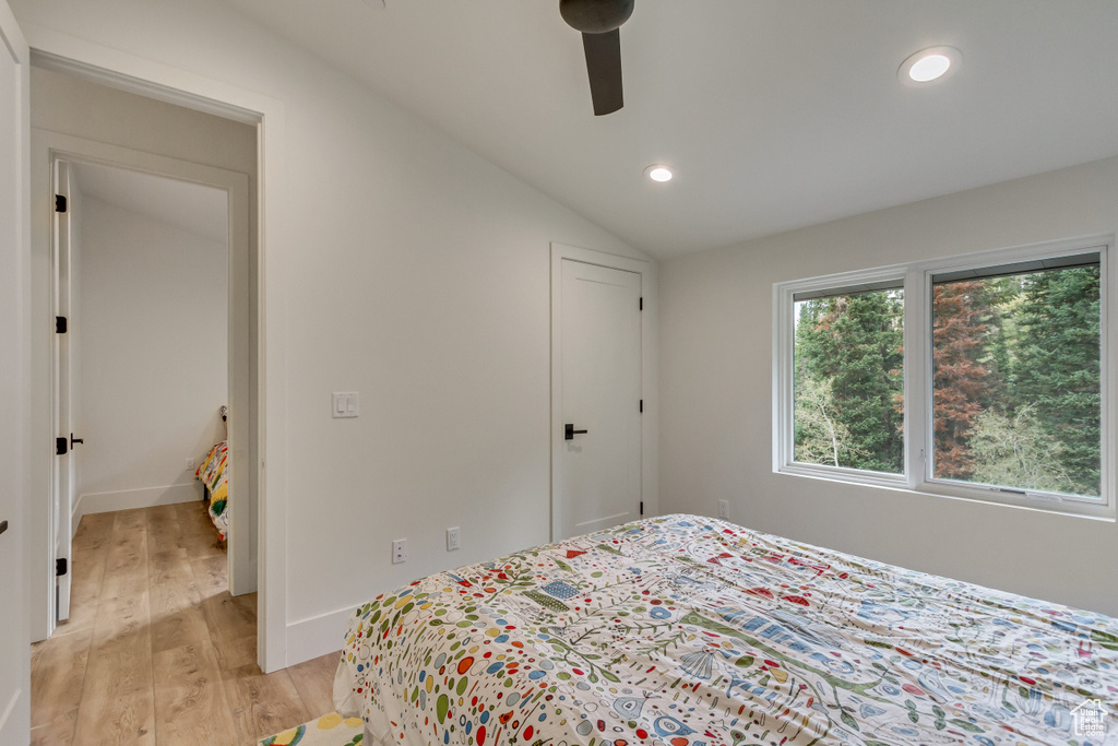 Bedroom featuring lofted ceiling, ceiling fan, and light wood-type flooring