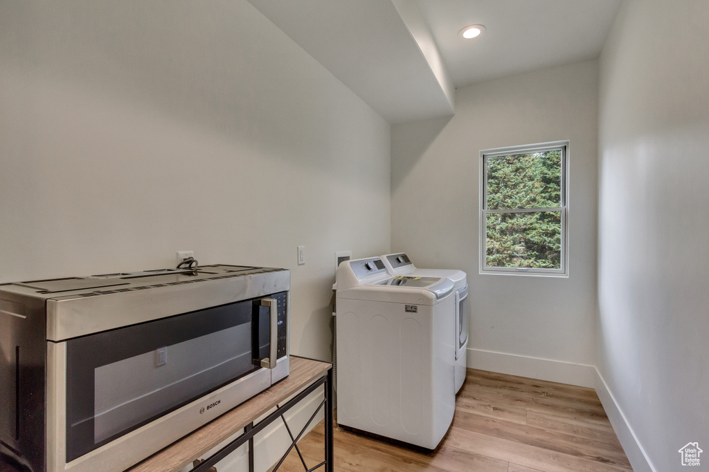 Laundry room featuring independent washer and dryer and light wood-type flooring