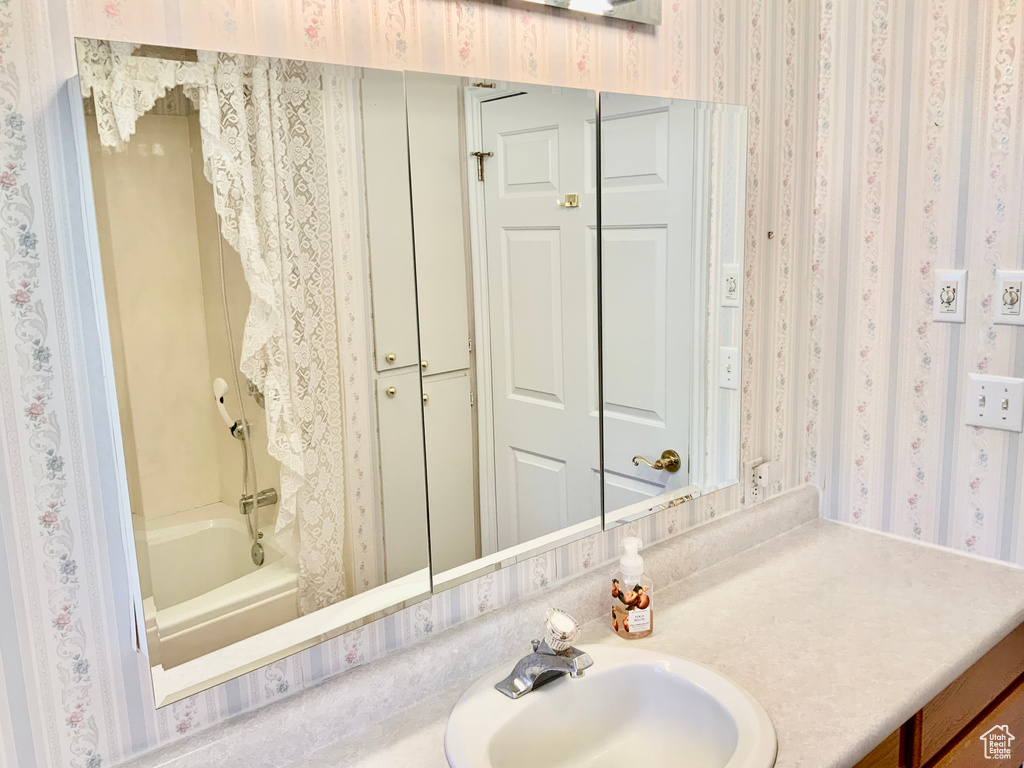 Bathroom featuring vanity with extensive cabinet space and bathing tub / shower combination